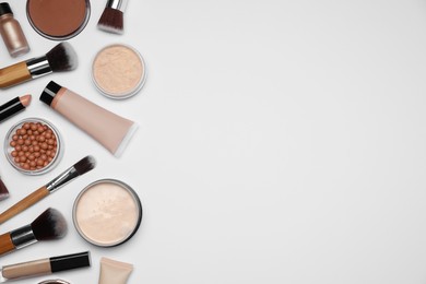 Photo of Face powders and other makeup products on white background, flat lay. Space for text