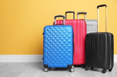 Photo of Different suitcases near color wall