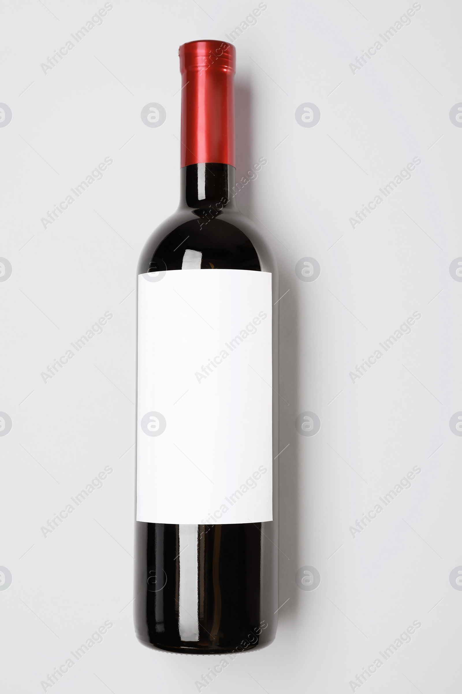 Photo of Bottle of delicious wine with blank label on white background