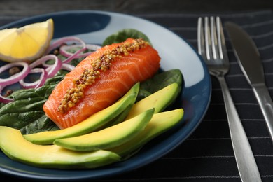 Photo of Delicious salmon with spinach and avocado served on fabric, closeup