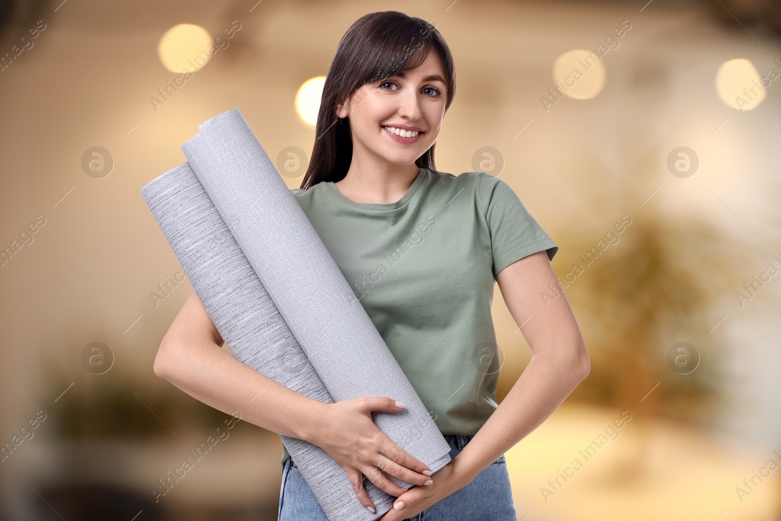 Image of Woman with wallpaper rolls on blurred background