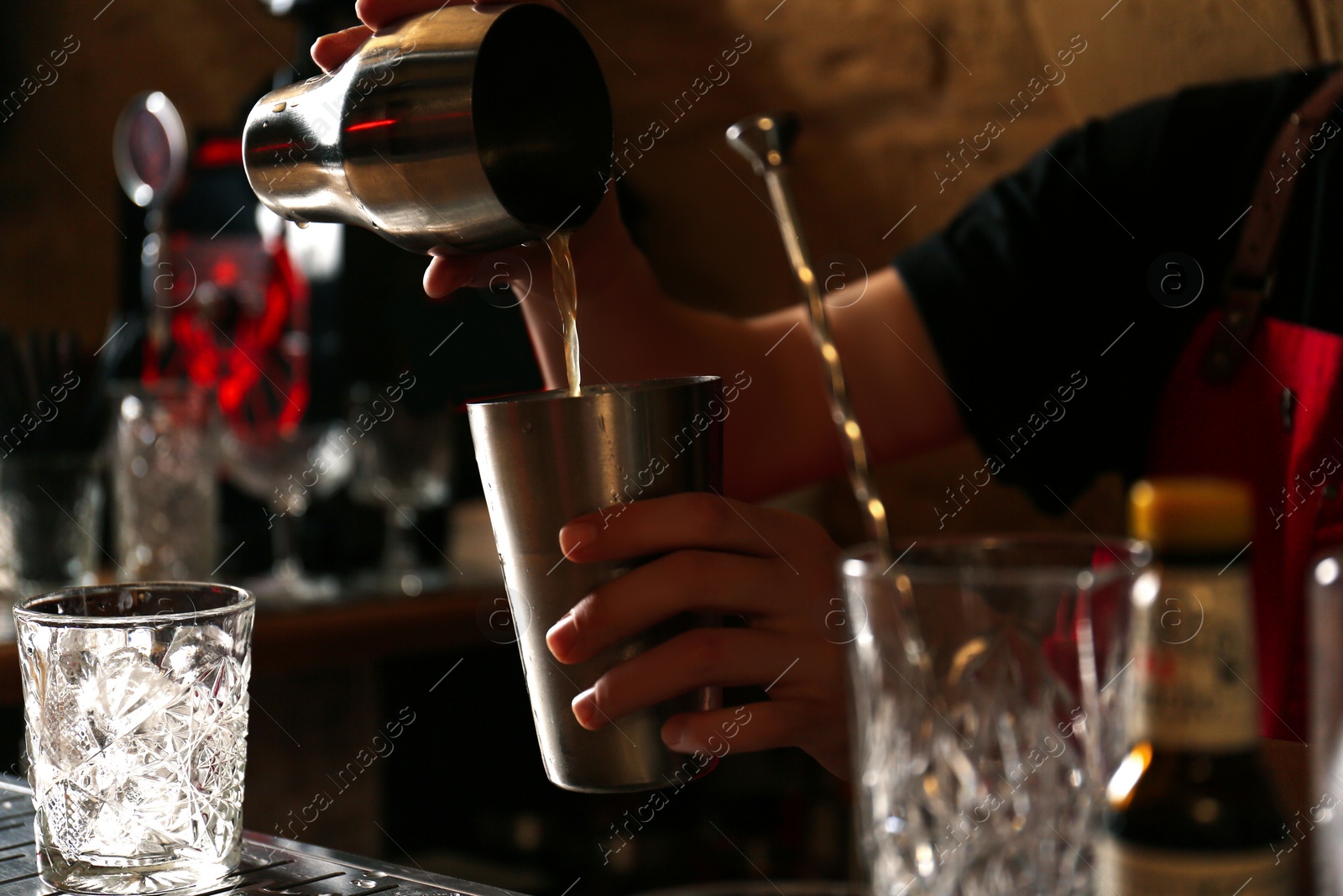 Photo of Bartender preparing fresh alcoholic cocktail at bar counter, closeup