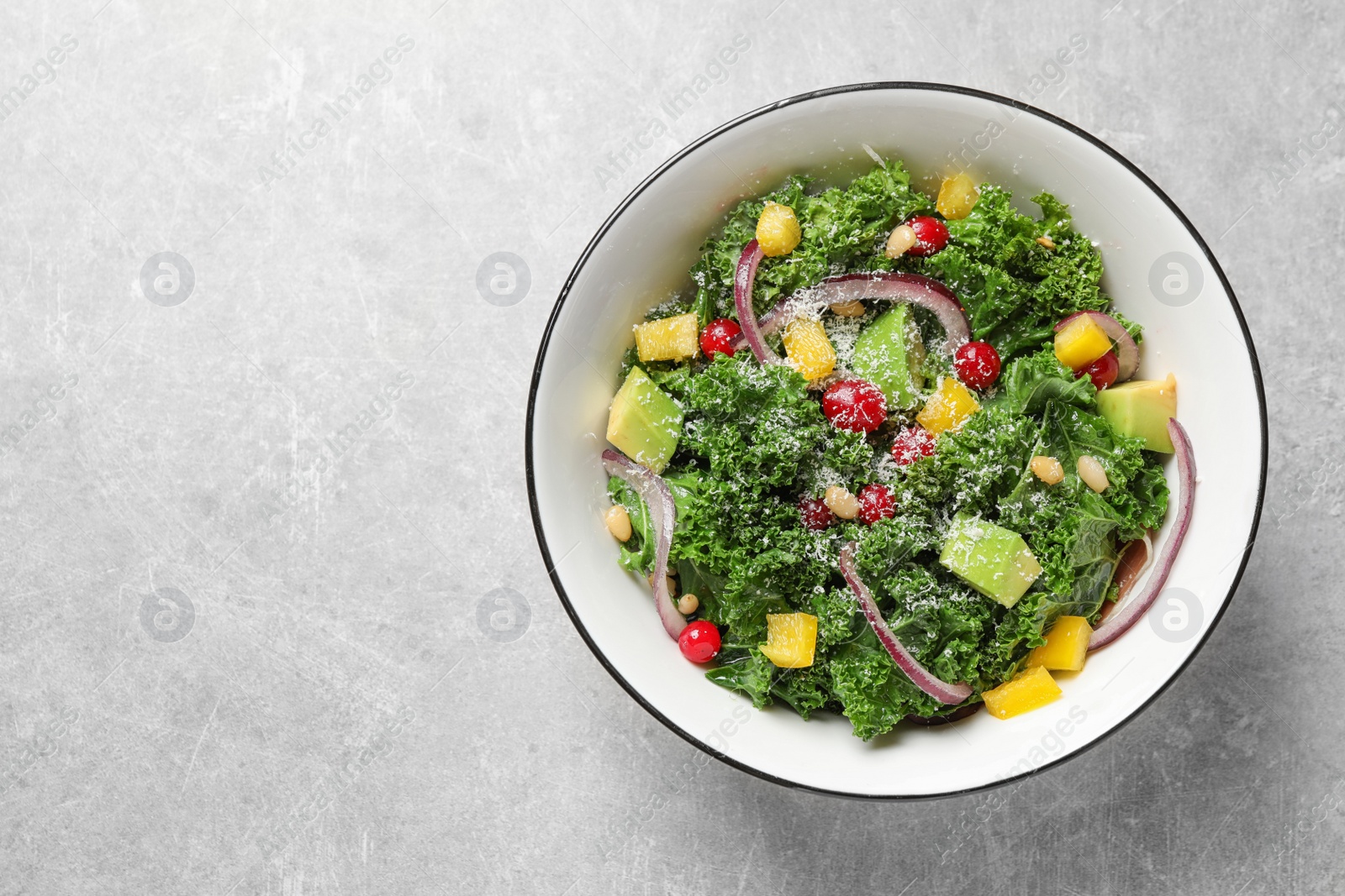 Photo of Tasty fresh kale salad on light grey table, top view