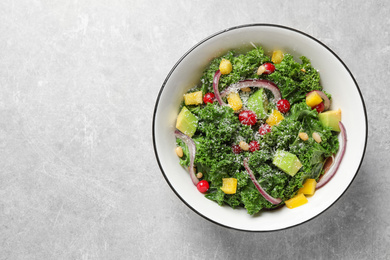 Photo of Tasty fresh kale salad on light grey table, top view