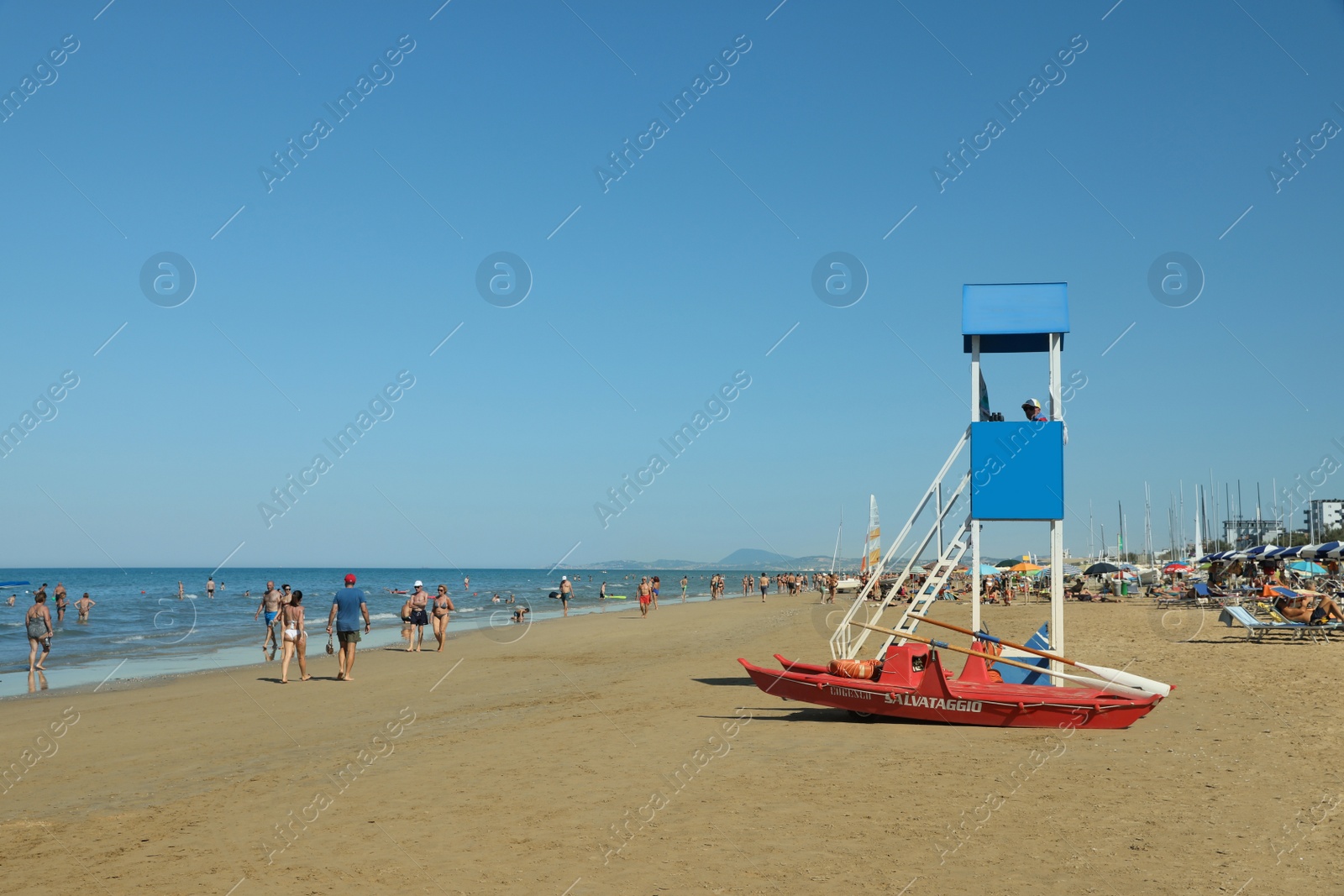 Photo of Lifeguard on watch tower and rescue boat near sea