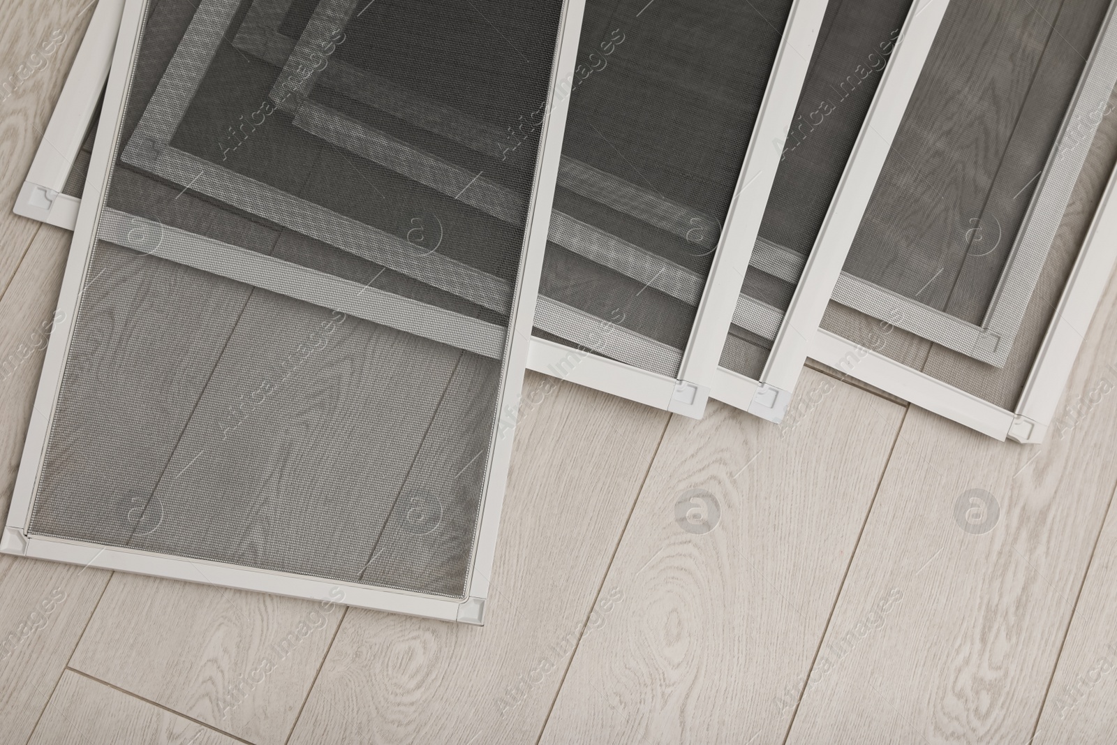 Photo of Set of window screens on wooden floor, flat lay