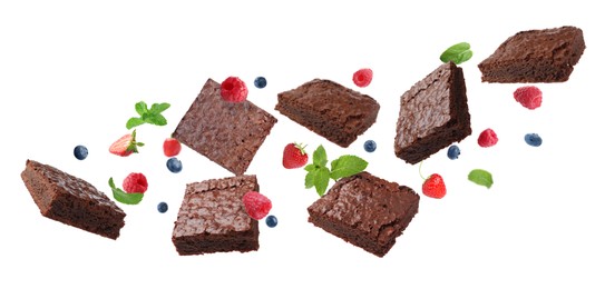 Image of Slices of delicious chocolate brownie with fresh berries and mint flying on white background. Banner design