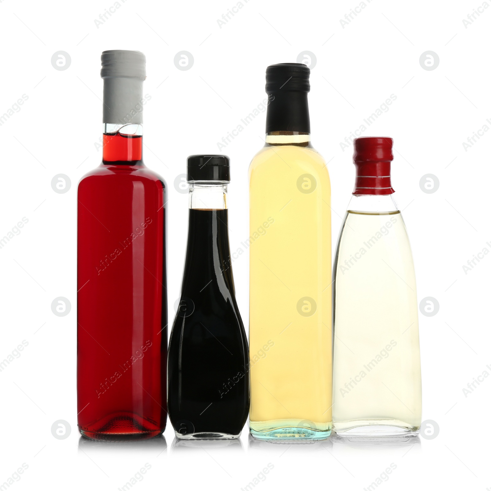 Photo of Bottles with different kinds of vinegar on white background