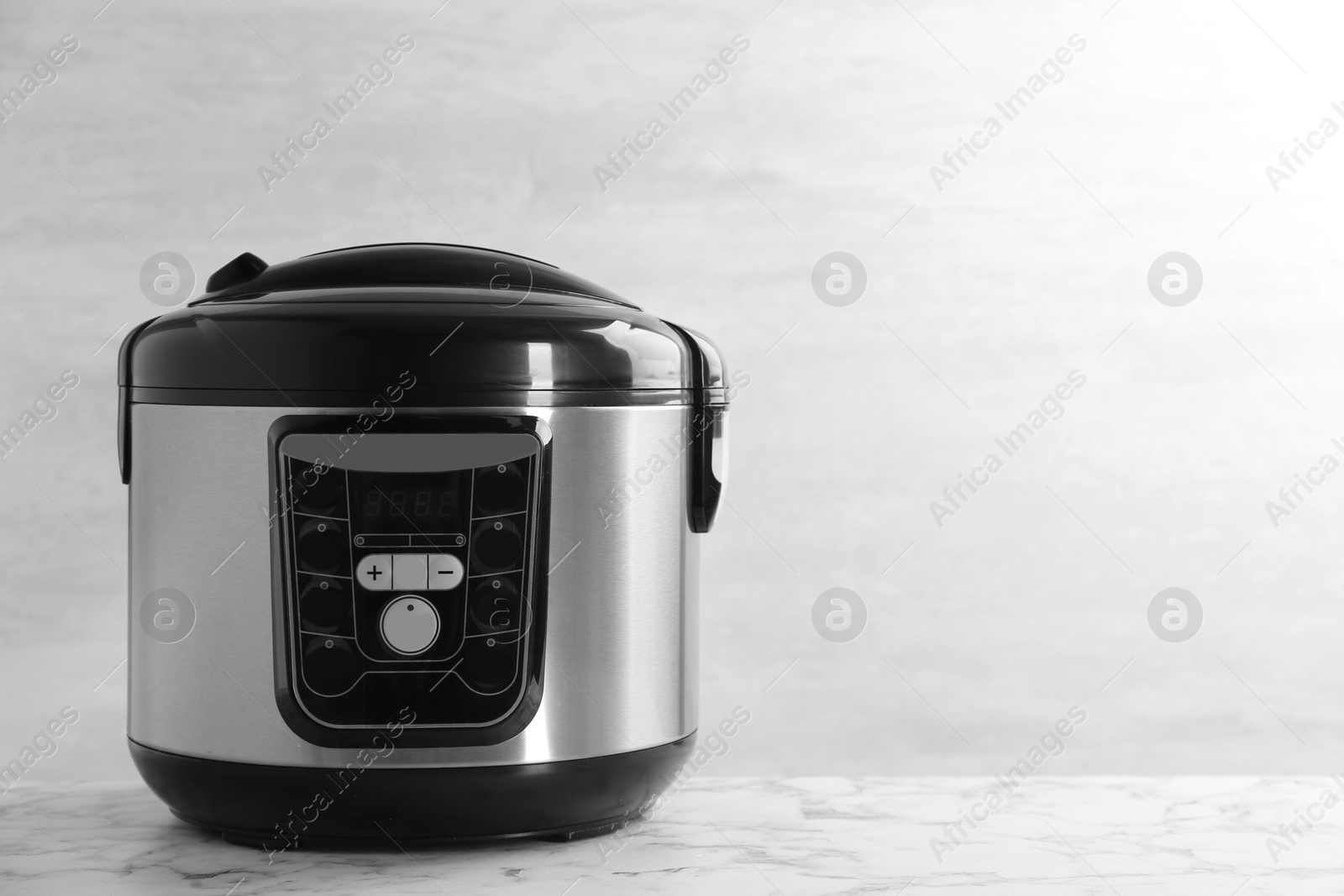 Photo of Modern powerful multi cooker on table against light background. Space for text