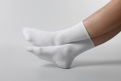 Photo of Man in stylish white socks on light grey background, closeup