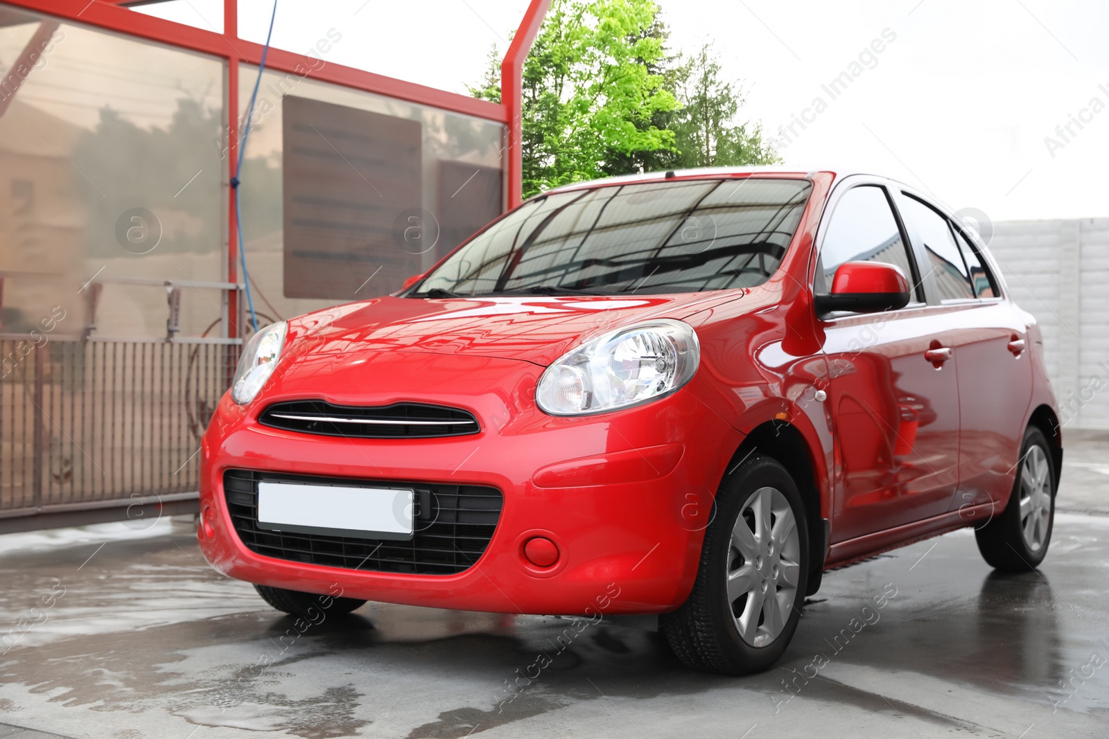 Photo of Red auto at car wash. Cleaning service