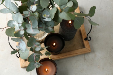 Photo of Burning candles and green branches on table, space for text