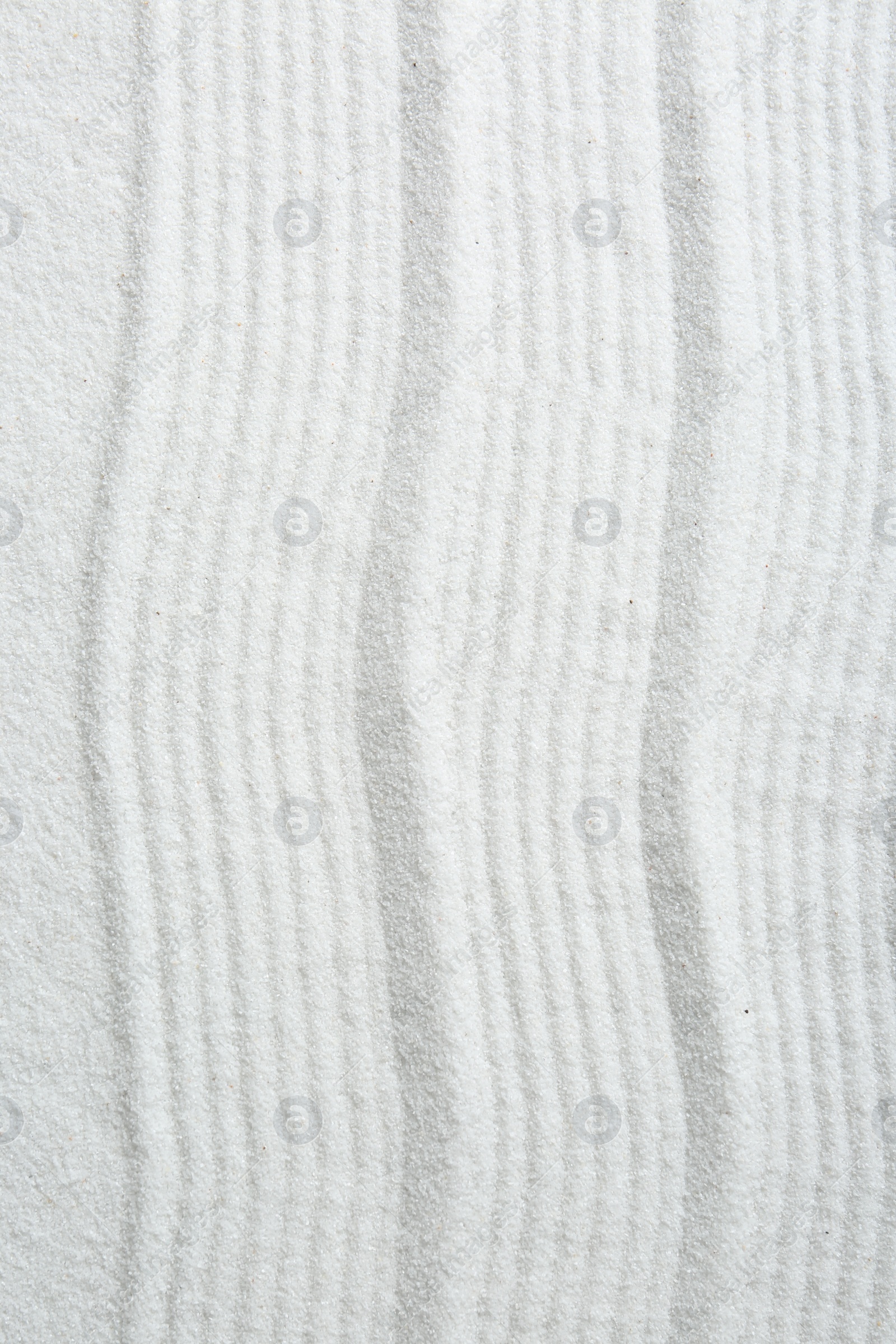 Photo of Zen rock garden. Wave pattern on white sand, top view