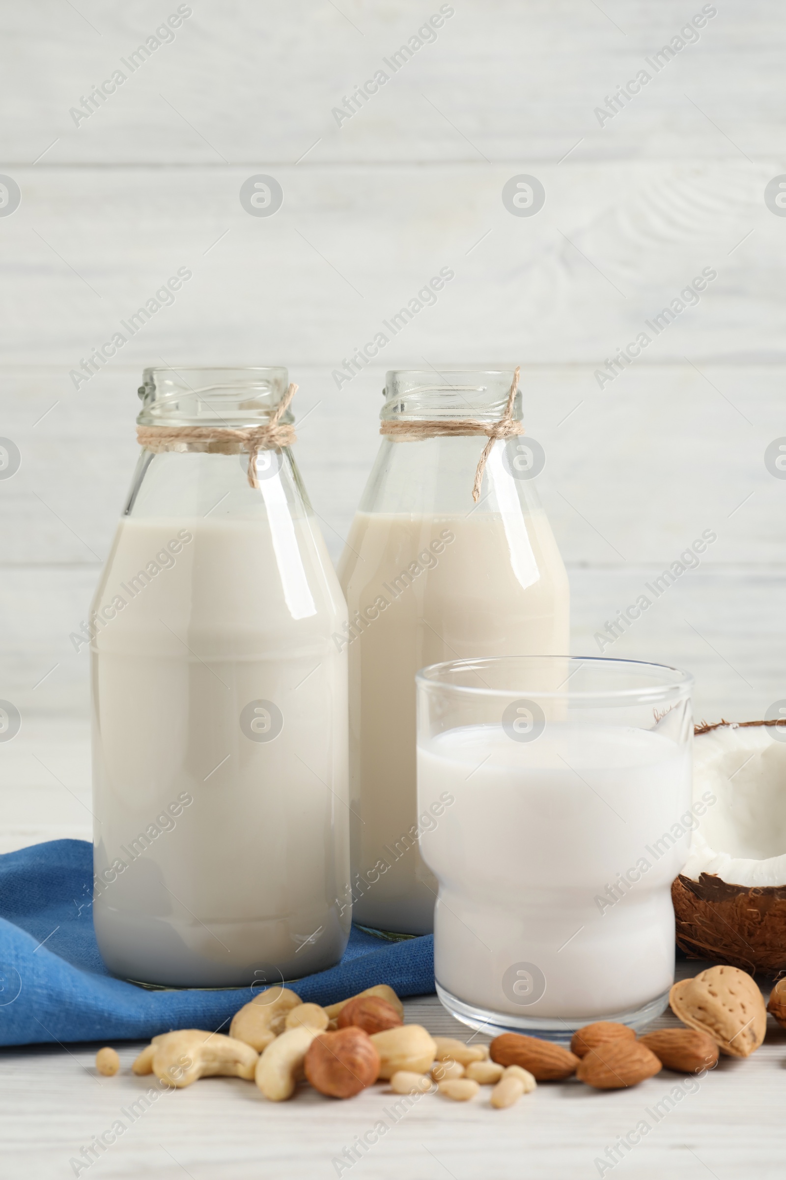 Photo of Different nut milks on white wooden table