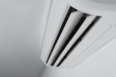 Photo of Modern air conditioner on white wall indoors, closeup