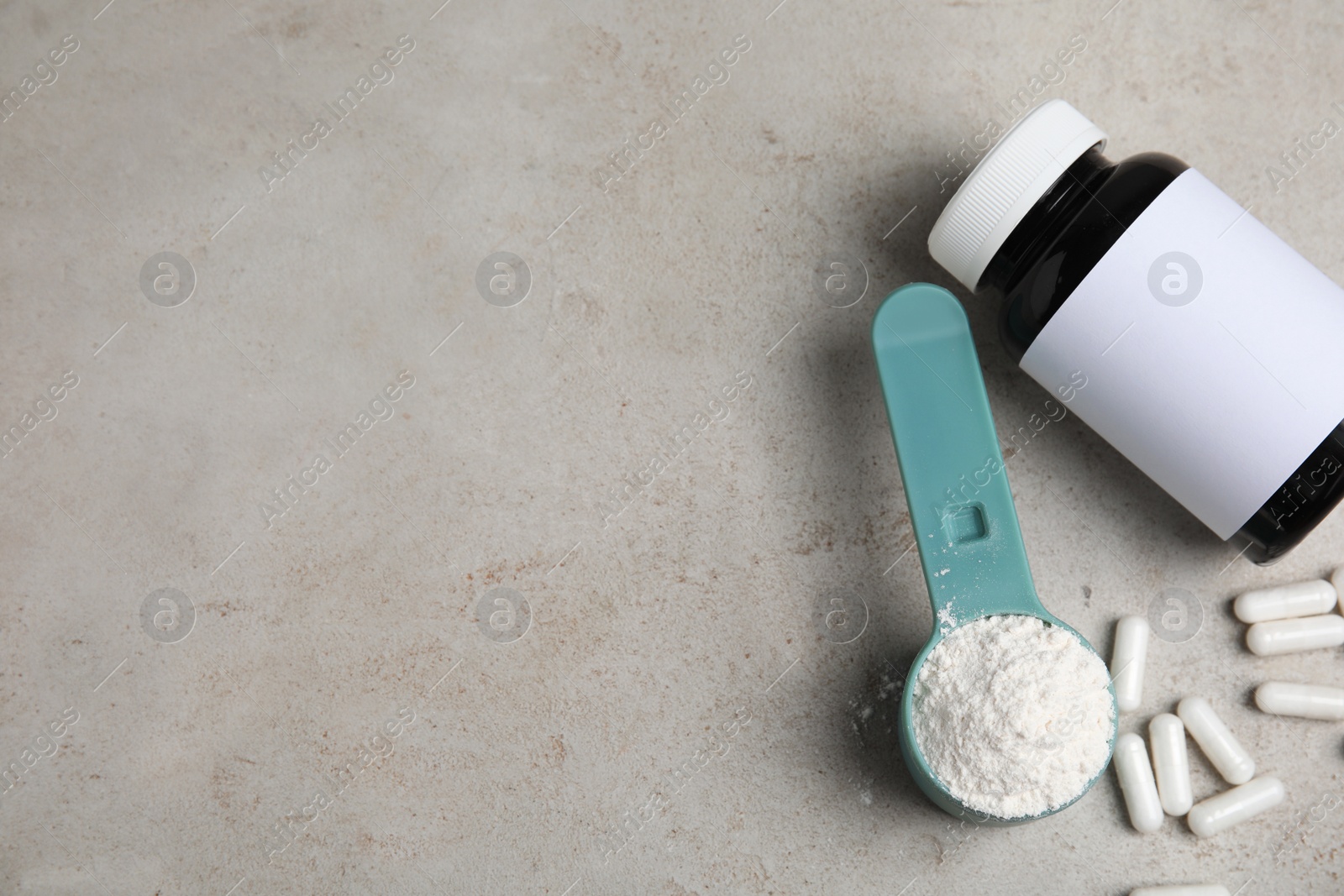 Photo of Amino acid pills and powder on grey table, flat lay. Space for text