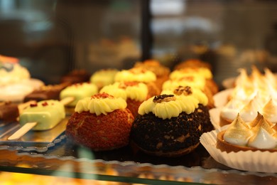 Different tasty desserts on counter in bakery shop, closeup. Space for text