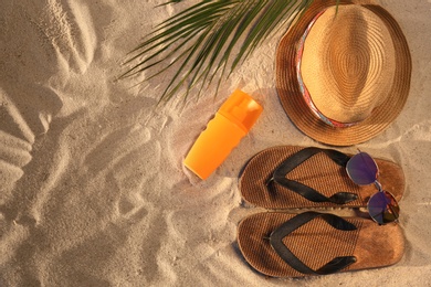 Photo of Flat lay composition with stylish beach accessories on sand. Space for text