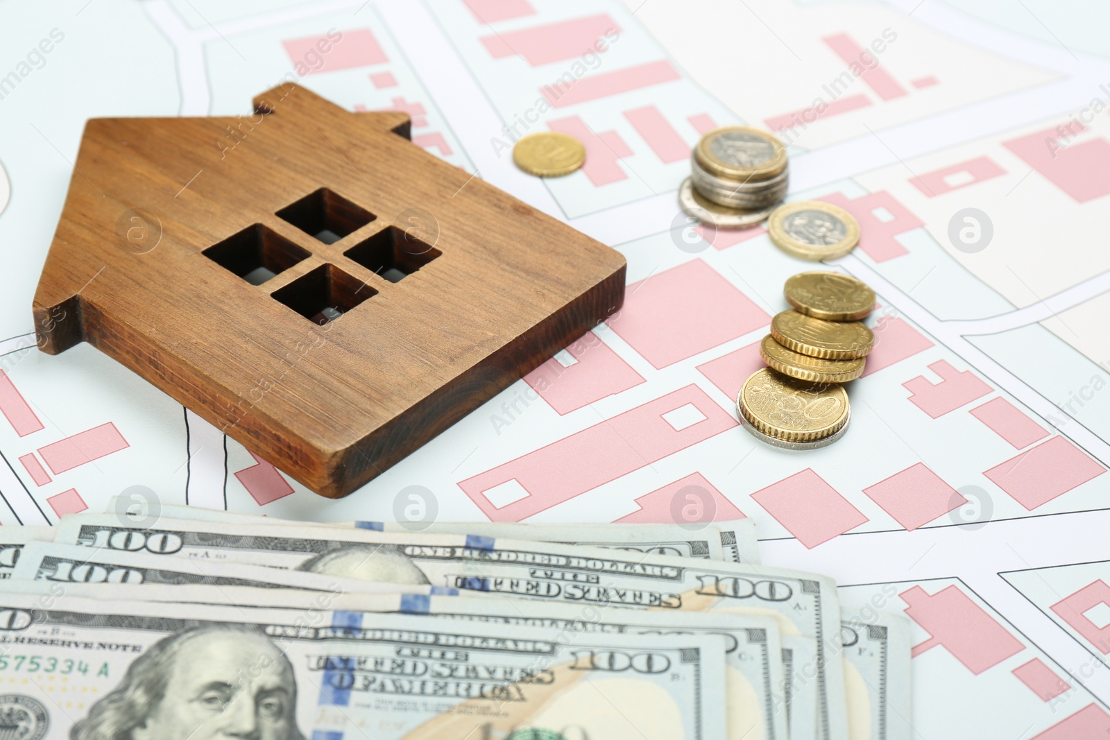 Photo of Money and wooden house model on cadastral map