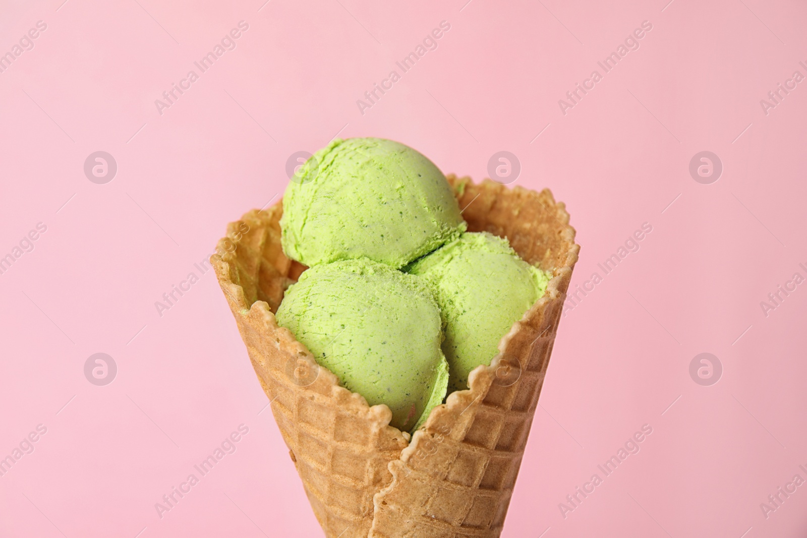 Photo of Delicious ice cream in waffle cone on color background