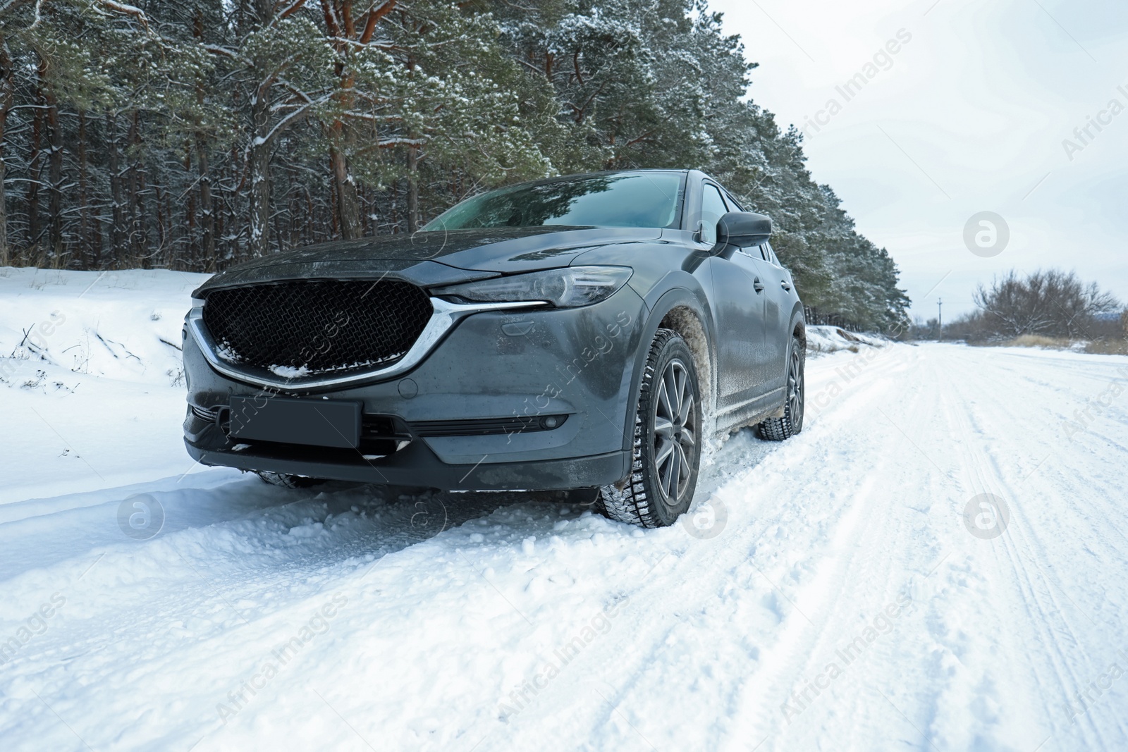 Photo of Snowy country road with car on winter day