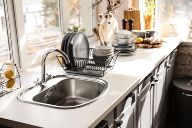 Photo of Stylish kitchen with sink and clean dishware