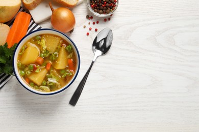 Photo of Bowl of delicious turnip soup served on white wooden table, flat lay. Space for text