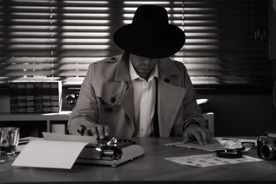 Old fashioned detective at table in office. Black and white effect