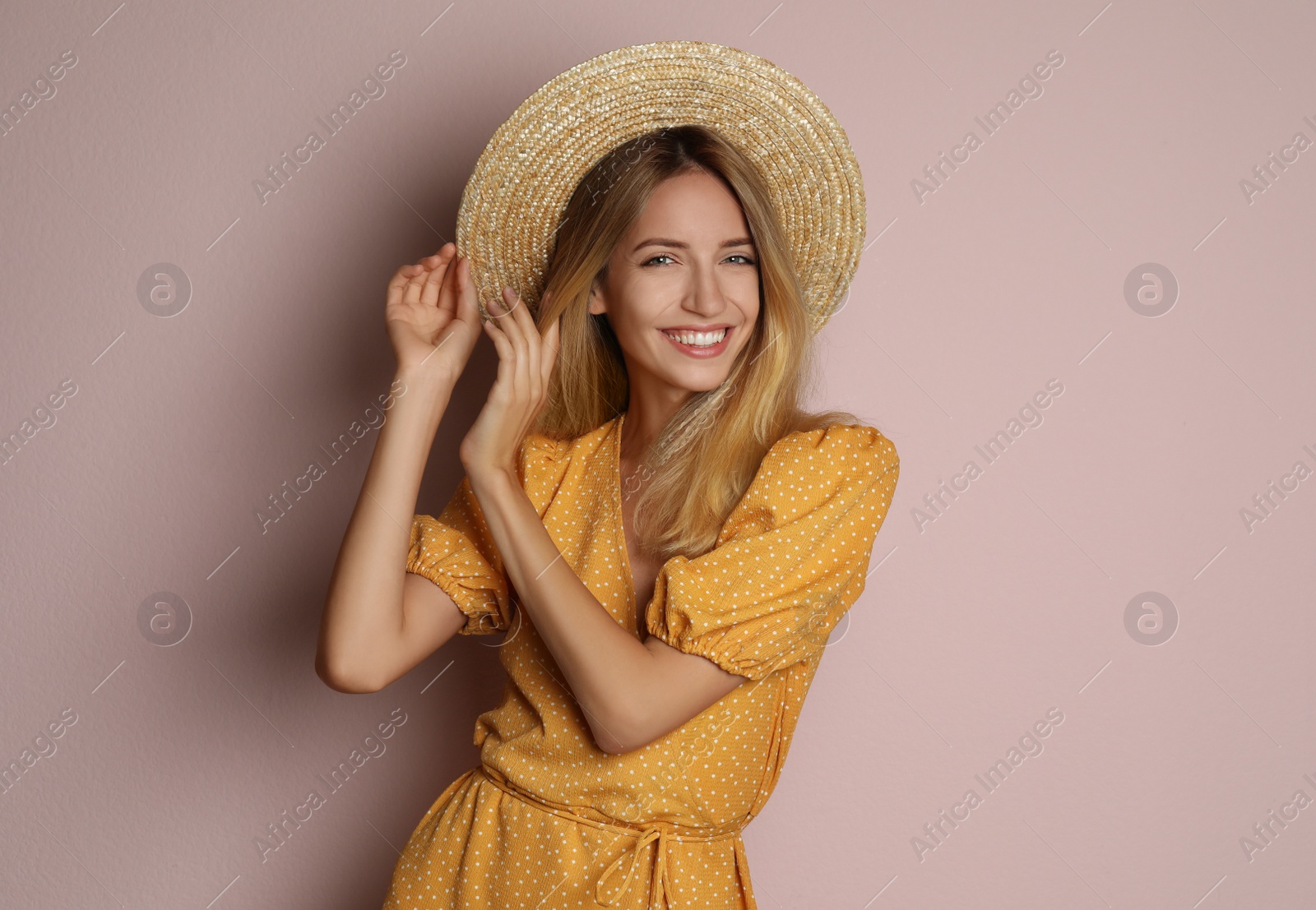 Photo of Young woman wearing stylish dress on pale pink background