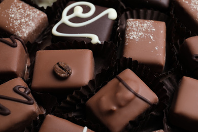 Photo of Different tasty chocolate candies as background, closeup