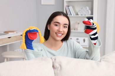 Happy woman performing puppet show at home