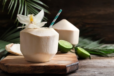 Photo of Fresh coconut drink in nut on wooden board