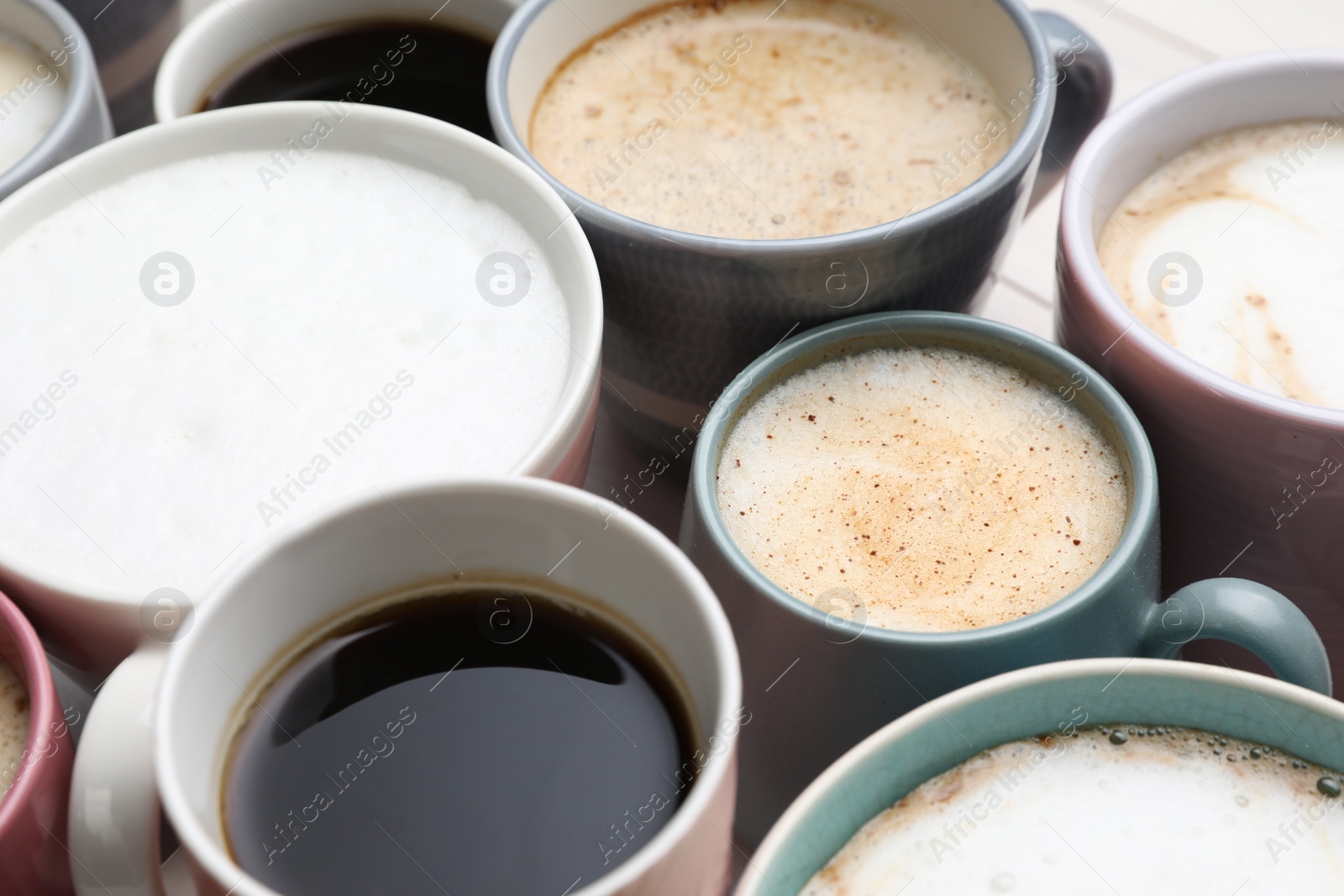 Photo of Many different cups with aromatic hot coffee on table, closeup