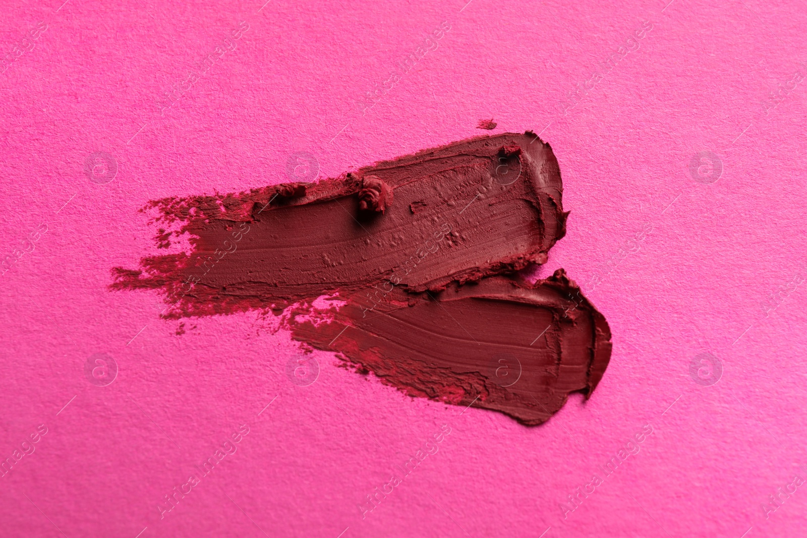 Photo of Smears of beautiful lipstick on pink background, top view