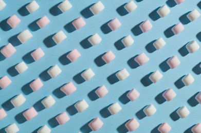 Photo of Delicious marshmallows on light blue background, flat lay