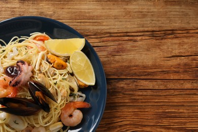 Delicious pasta with sea food on wooden table, top view. Space for text