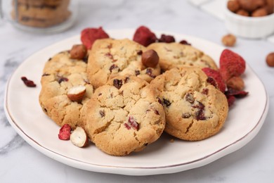 Photo of Cookies with freeze dried fruits and nuts on white marble table, closeup