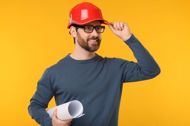 Photo of Architect in hard hat with draft on orange background