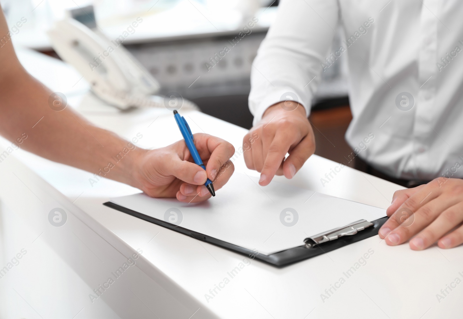 Photo of Young man signing documents in car salon