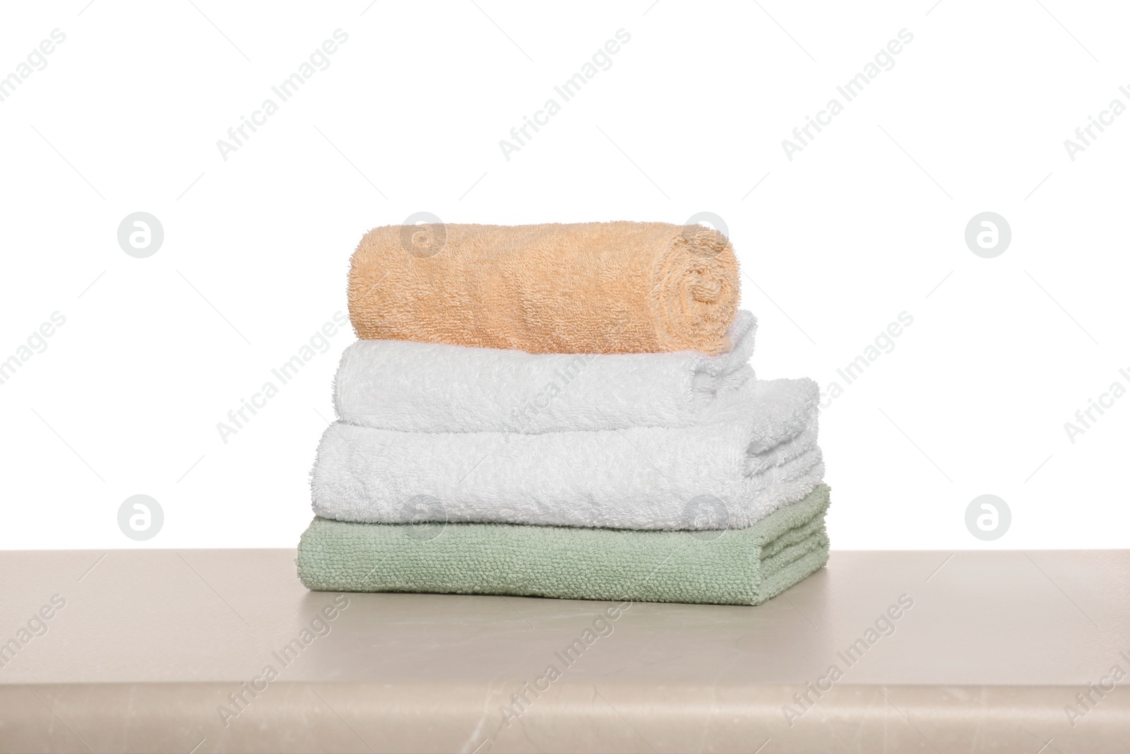 Photo of Soft colorful terry towels on light table against white background