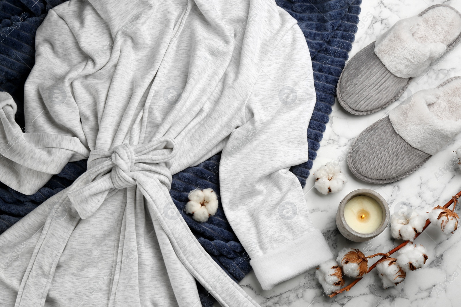 Photo of Flat lay composition with slippers and robe on white marble background. Comfortable home outfit