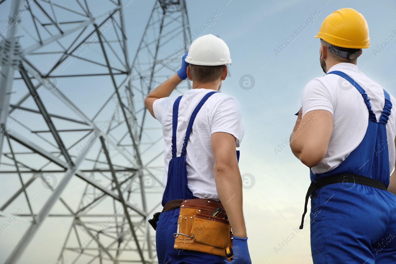 Photo of Professional engineers working on installation of electrical substation outdoors