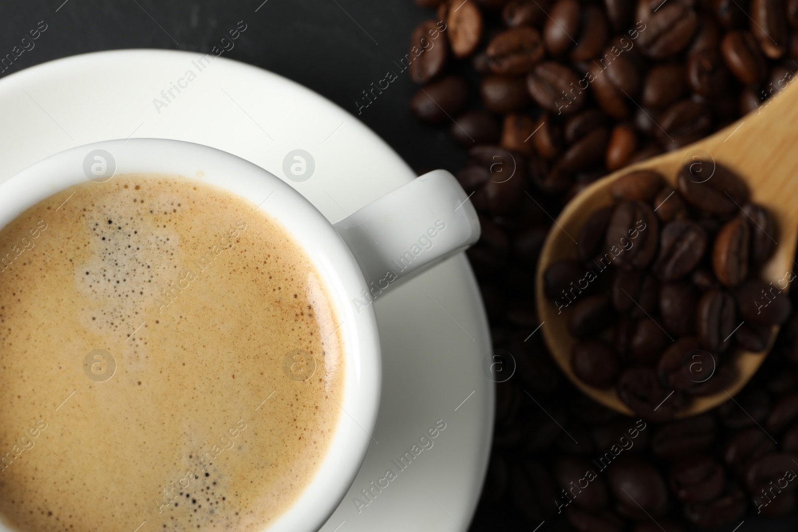 Photo of Cup of aromatic coffee and beans on grey table, flat lay. Space for text