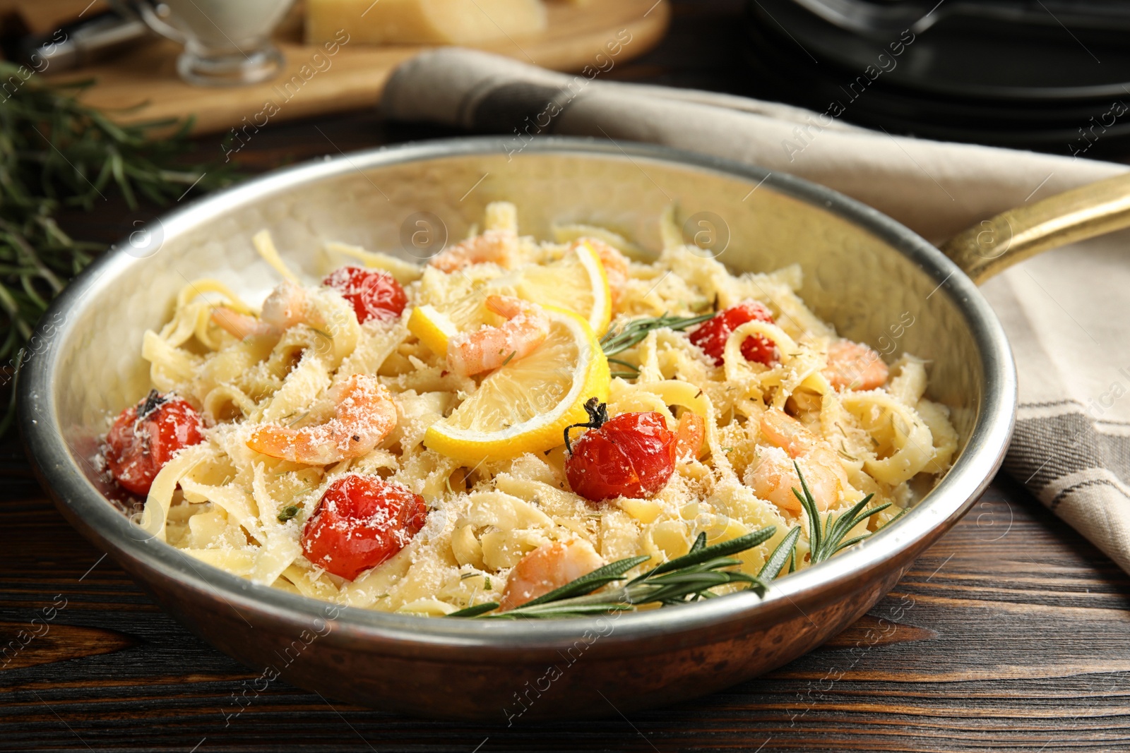Photo of Delicious pasta with shrimps on wooden table
