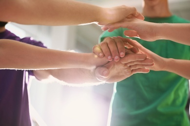 Photo of Group of volunteers joining hands together, closeup