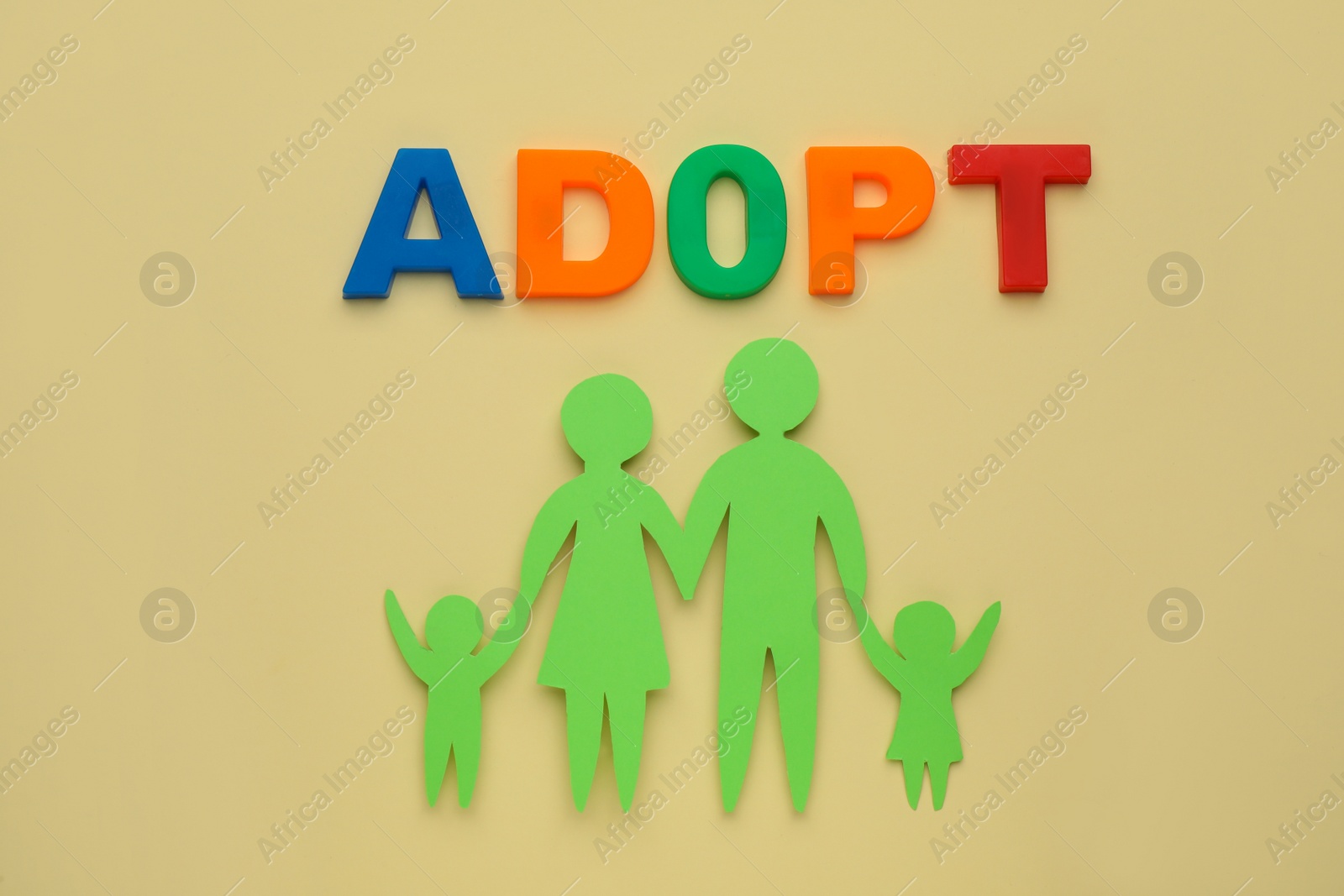 Photo of Family figure and word Adopt on beige background, flat lay