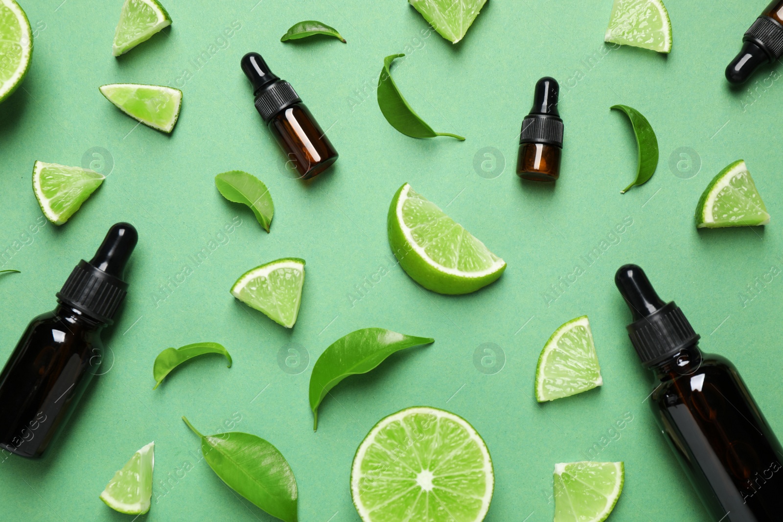 Photo of Flat lay composition with lime essential oil on green background