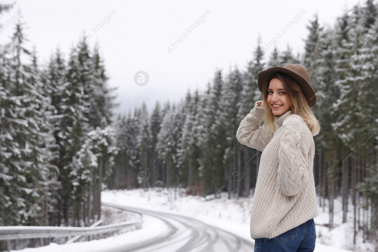 Photo of Young woman walking near snowy forest. Winter vacation