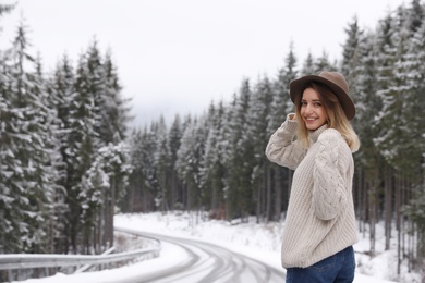 Photo of Young woman walking near snowy forest. Winter vacation