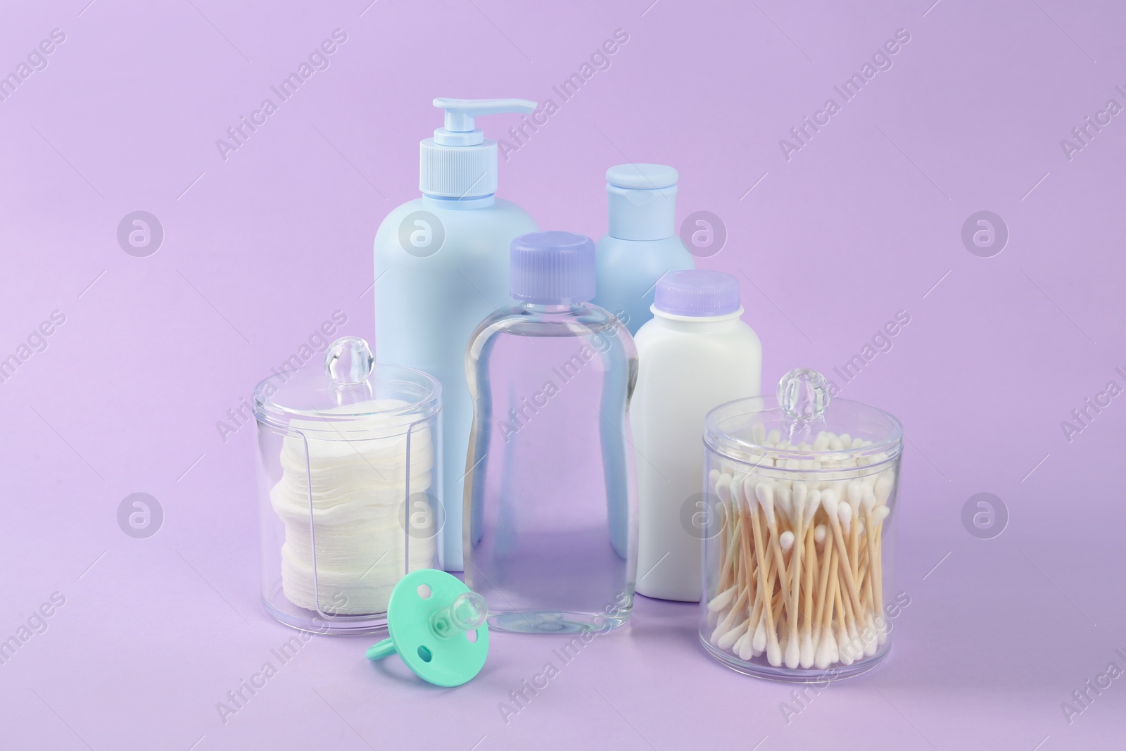 Photo of Different skin care products for baby and pacifier on violet background